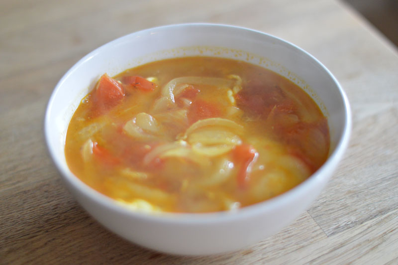 A simple tomato and onion broth with poached egg