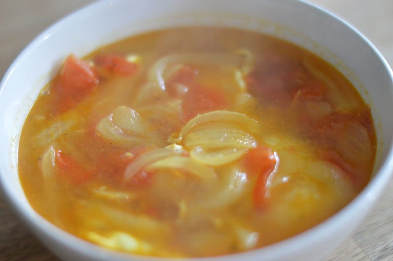 A simple tomato and onion broth with poached egg